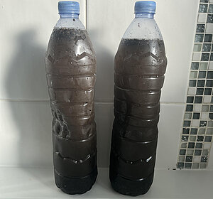 Two large drinks bottles of raw sewage