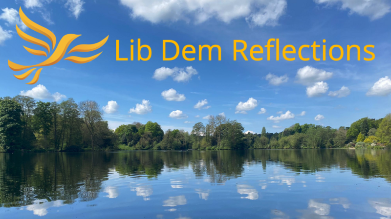 Lib Dem Reflections, Tree lined lake reflected in the water - Photo Chloe Clutterham